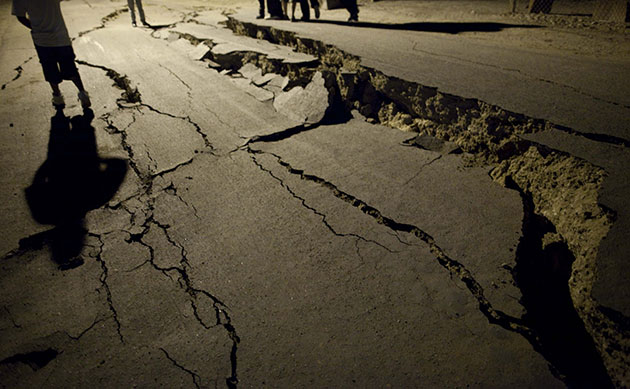 24 hours in pictures: Mexicali, Mexico: Men stand next to cracks on a street