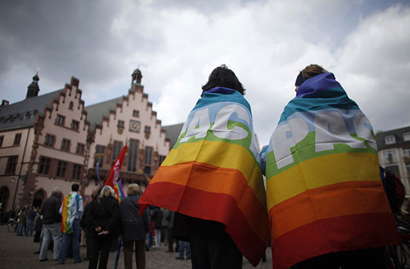 24 hours in pictures: Frankfurt, Germany: A couple wrapped in peace flags