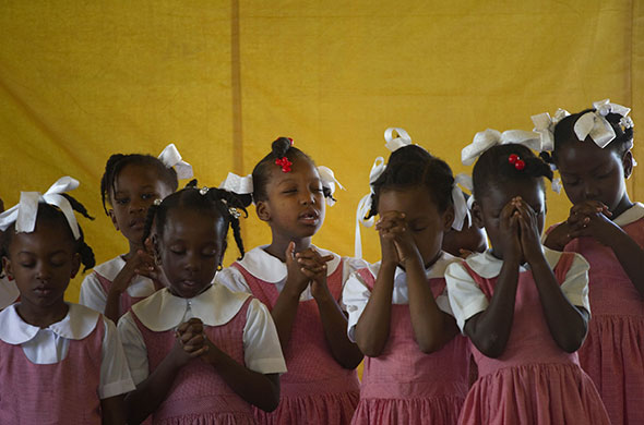 24 hours in pictures: Port-au-Prince, Haiti: School girls pray before class