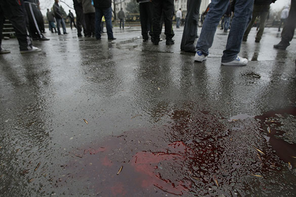 Kyrgyzstan: Protestors stand near pools of blood