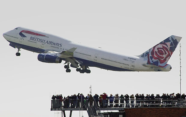 British Airways merger: 2001: A BA Boeing 747 flying over planespotters at Heathrow airport