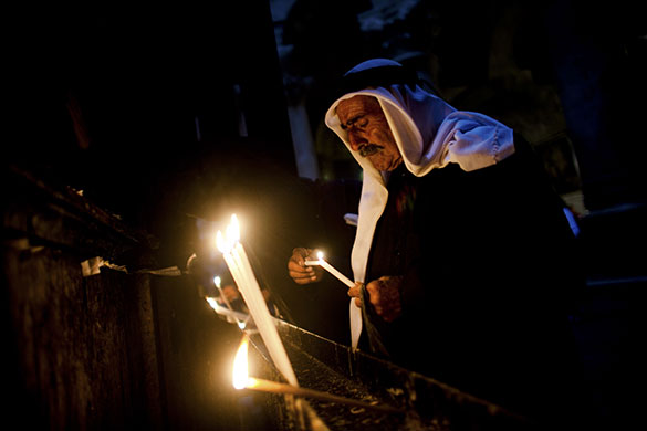 24hours: A Palestinian Christian lights a candle at a Church