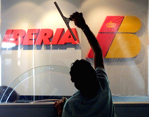 British Airways merger: 2001: A worker cleans a glass of the Iberia office at Mallorca's airport