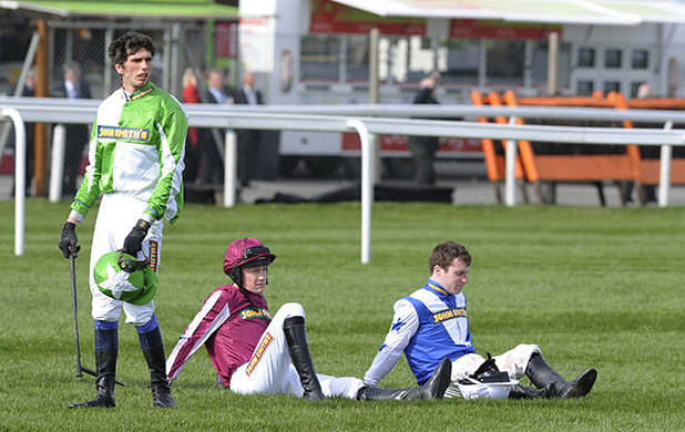 Grand National day one: Some of the fallen jockeys watch the finale of the Foxhunters chase