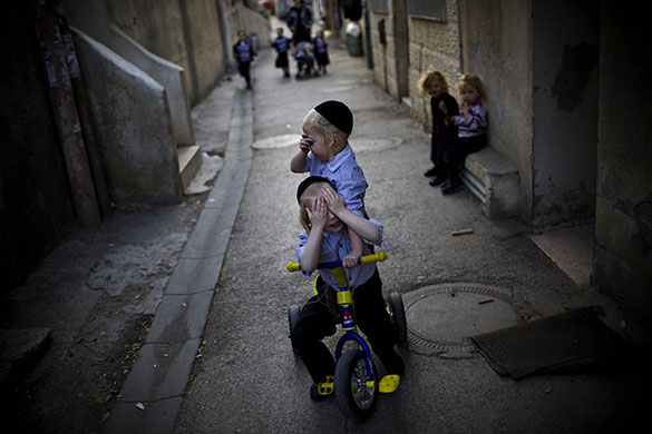 24 hours in pictures: Jerusalem:  Jewish children cover their faces as they play in a street 