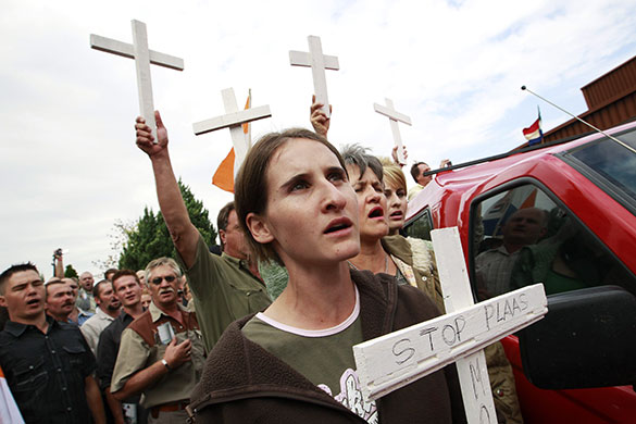 terreblanche update: People hold crosses during the funeral of Eugene Terre'Blanche