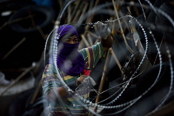 24 Hours in Pics: Red shirt anti-government protesters rebuild a barricade in Bangkok