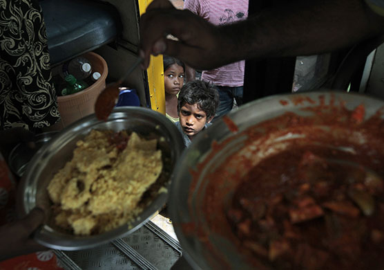 24 Hours in Pics: Children from a shanty await their turn to receive free food in Mumbai