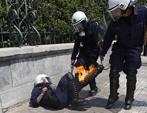 24 Hours in Pics: Greek riot policeman try to extinguish flames on a colleague in Athens