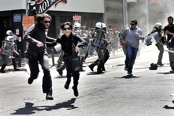 Athens Riot: Demonstrators run away from riot police during a May Day protest in Athens