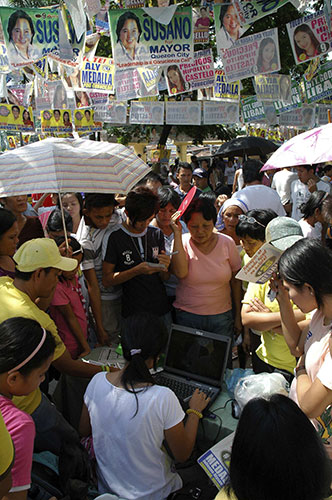 Philippine elections: Filipino voters check their names on a computer outside a school precinct