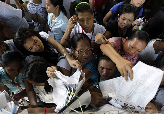 Philippine elections: Filipino voters look for their names on the voters' lists at a school 