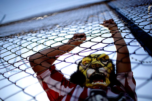 24 hours in pictures: An Estudiantes de La Plata soccer fan wears a mask of his team's mascot