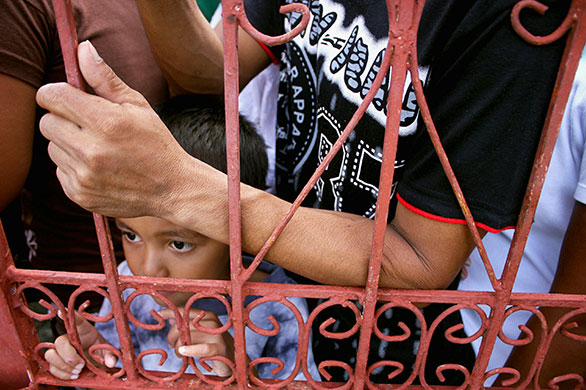 24 hours in pictures: Filipino voters wait to enter a polling centre to cast votes