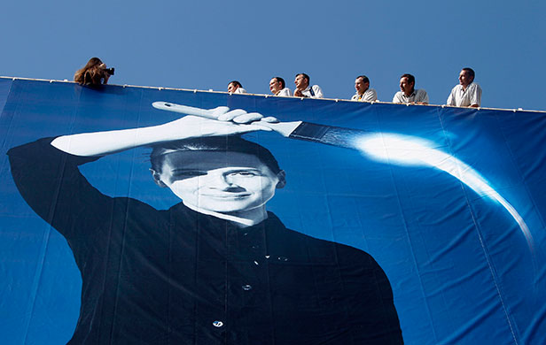 24 hours in pictures: Workers after positioning a giant canvas of the 63rd Cannes Film Festival