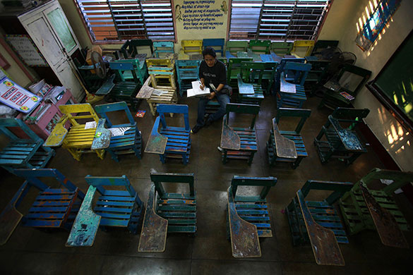 Philippine elections: A man fills out his vote ballot in a classroom in Pasay City