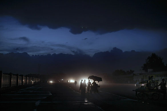 24 hours in pictures: Kabul, Afghanistan: Men buy food from a street vendor