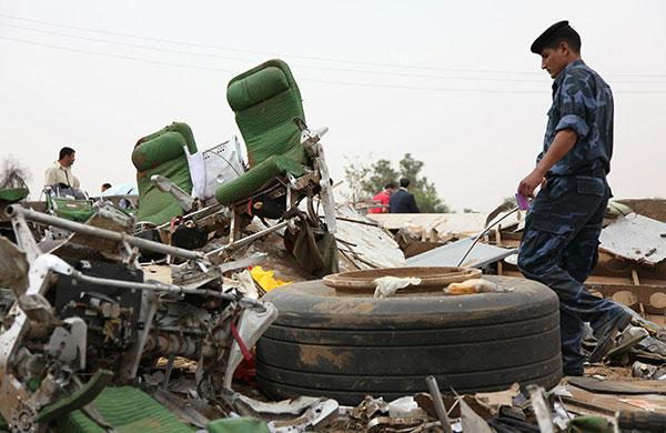 Libya plane crash: A policeman walks amid the debris of an Afriqiyah Airways passenger plane