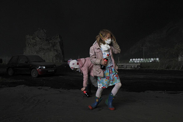 24 hours in pictures: Eyjafjoll, Iceland: Girls play in ash from Eyjafjallajokull volcano