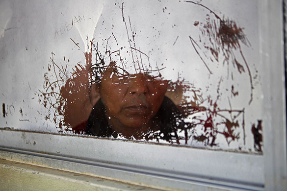 24 Hours in Pics: The mother of a ballet student looks through a window at the studio