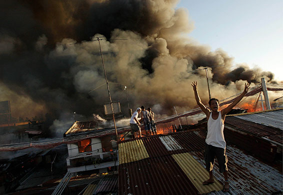 24 Hours in Pics: A Filipino resident shouts for water during a fire in Muntinlupa City