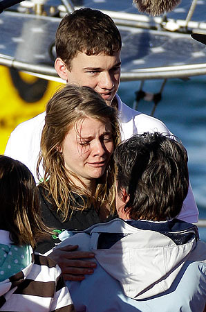 Jessica Watson hugs her mother as her brother looks on in Sydney after her world-record sailing bid