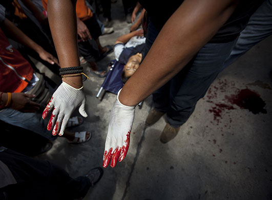 Bangkok Riots: An anti-government supporter moves a man shot dead in Bangkok