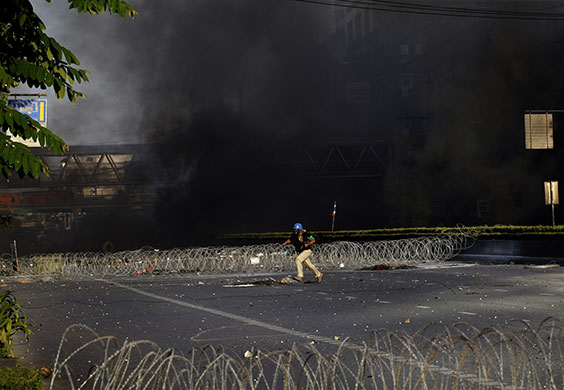 Bangkok Riots: A media person runs for cover amidst a firing in Bangkok