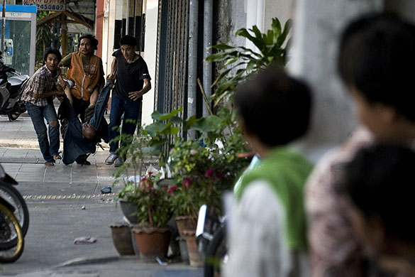 Bangkok Riots: Anti-government protesters carry a civilian after he was shot