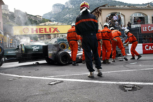 Monaco grand prix: Race marshalls clear the crashed car of Trulli and Chandhok