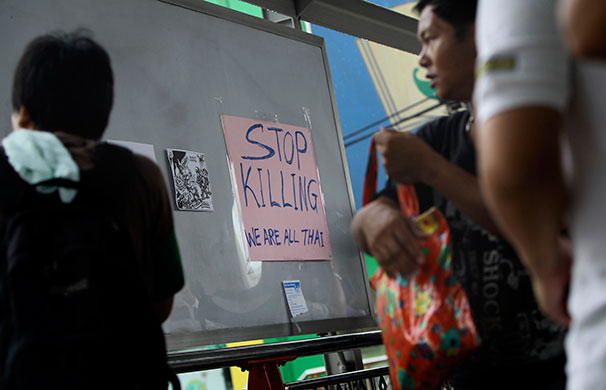 Thailand protests: Pedestrians pass a sign calling for peace