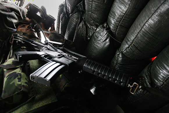bangkok standoff: A  soldier looks through binoculars in Bangkok 
