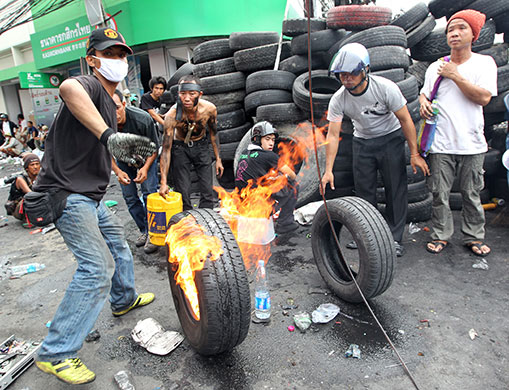 Thai clashes: Red shirt anti-government protesters burn tires to prevent troops shooting