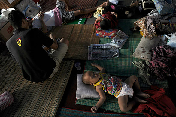 Thai clashes: Children sleep on mats at a temple turned into a temporary shelter
