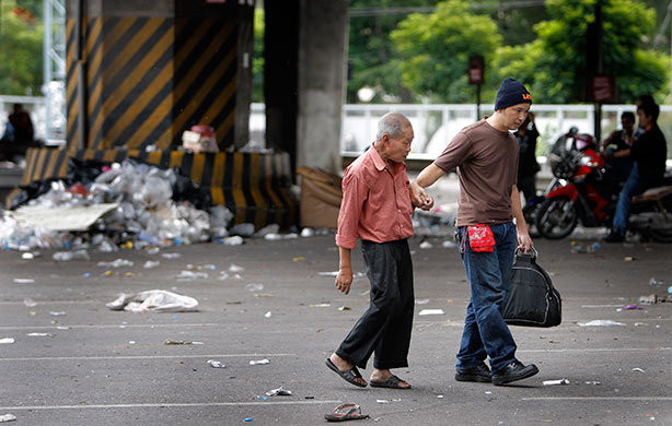 Thai clashes: An elderly man is helped across a street as he leaves clash points