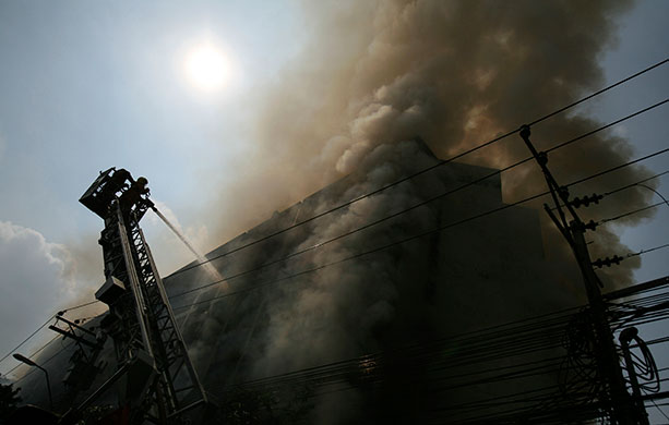 Thai clashes: Firemen hose down a fire at the site of clashes 