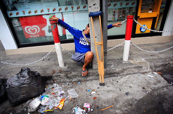 Thai clashes: A man sleeps on a deserted sidewalk