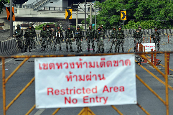 Thai clashes: Armed soldiers stand behind barbed wire