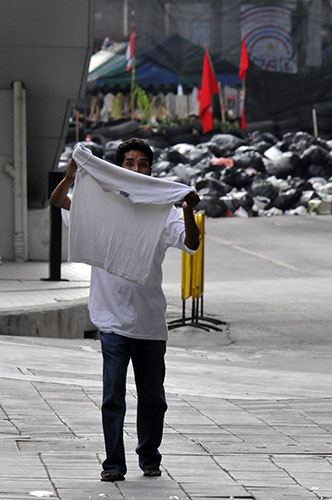 protests in Thailand: An anti government protester waves a white shirt as he surrenders
