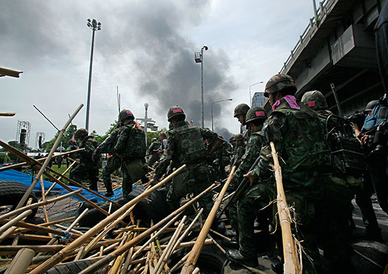 Bangkok protests: Soldiers charge through an anti-government barricade