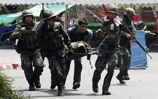Bangkok protests: Soldiers carry a fellow soldier on a stretcher