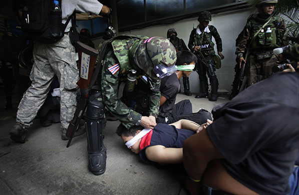 Bangkok crackdown: A soldier blindfolds an anti-government protester