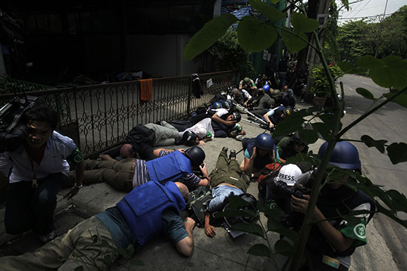 Bangkok crackdown: Journalists take cover during a gun battle