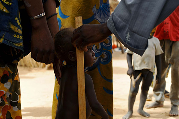 Niger Children: Marcia being measured for signs of malnutrition by volunteer Zani Malaharou
