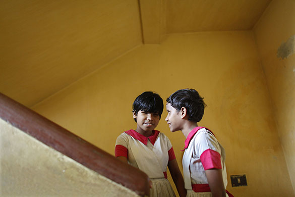 24 hours in pictures: Dhaka, Bangladesh: Students, Tania  and Meem, climb up a flight of stairs