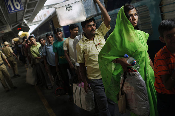 24 hours in pictures: New Delhi, India: People wait to board a crowded train