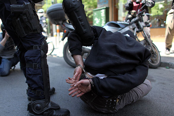 May Day protests: Athens, Greece: A policeman detains a demonstrator