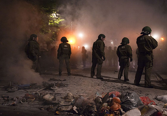 May Day protests: Berlin, Germany: Riot police stand next to burnt rubbish containers