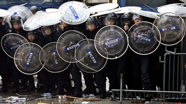 24 hours in pictures: Macau, China: Policemen protects themselves from protestors
