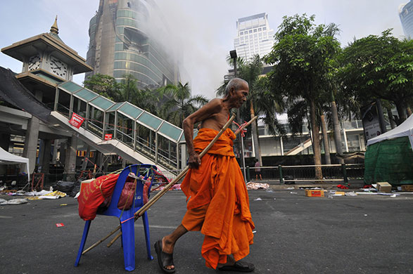 Thailand: A Buddhist monk drags his belongings on a plastic chair 